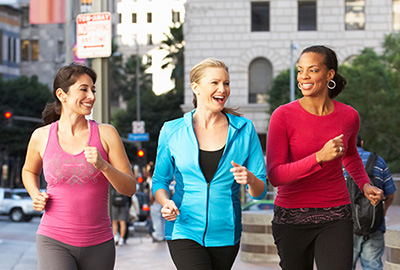 Group Of Women Power Walking On Urban Street